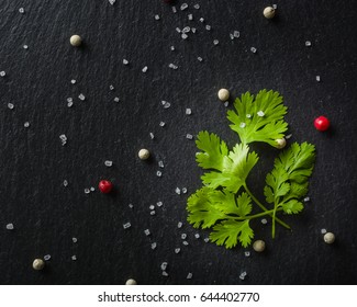 Green Fresh Parsley On Black Slate With Seasoning And Salt. View From Above.