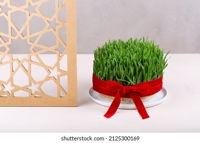 Green Fresh Semeni Sabzi Wheat Grass In White Plate Decorated With Red Ribbon With Wooden Shebeke Pattern, Novruz Spring Equinox Celebration In Azerbaijan