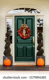 Green Front Door With Fall Autumn Wreath With Leaves And Topiaries And Pumpkins