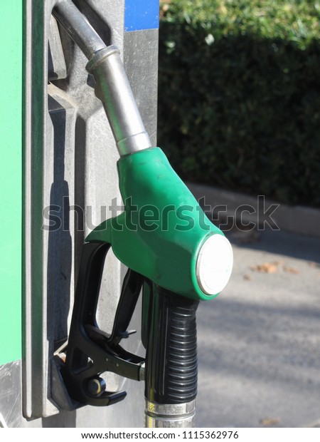 Green fuel pistol on gas station . Unleaded\
petrol at the pump\
station