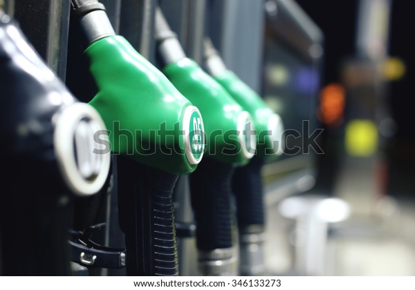 Green fuel pistols on fuel
station.