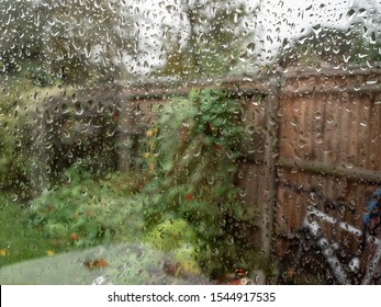 Green garden seen through rain splattered window