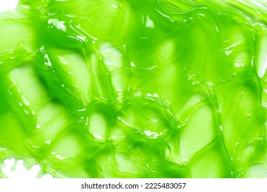Green gel slime, cosmetic product as background, skin care mask or peeling gel texture swatch.
