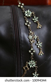 Green Gemstone Necklace Against Brown Leather Boots