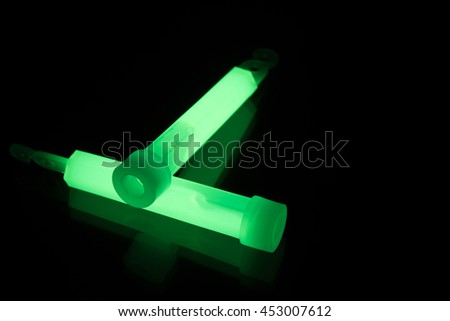 Green glowsticks on a reflective surface