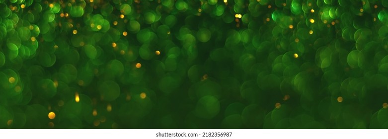 Green And Golden Sparkling Glitter Bokeh Background, Christmas Texture. Holiday Lights. Abstract Defocused Header. Wide Screen Wallpaper. Panoramic Web Banner With Copy Space For Design