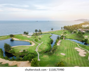 Green of the golf course, Built adjacent to the beach and the sea. Is a field with Atmosphere SpontaneityAnd relax. There is a mountain and blue sky at background.