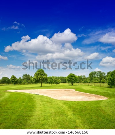 green golf course and dramatic blue sky. european field landscape