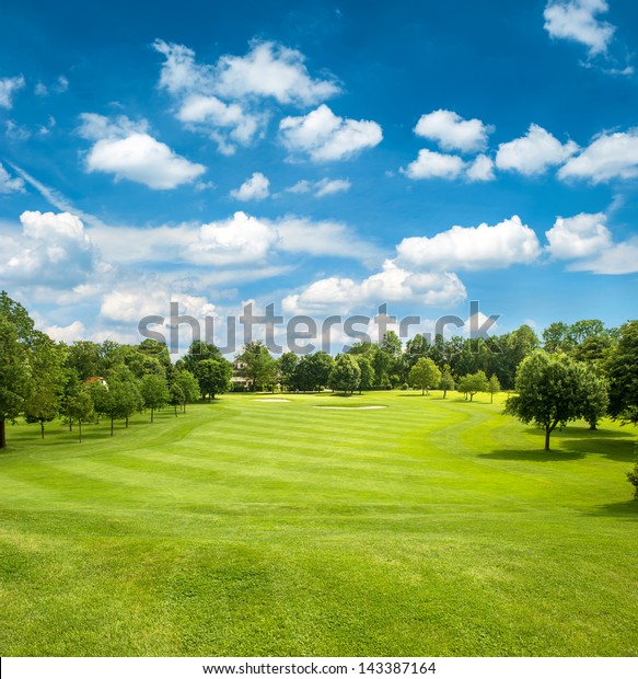 green\
golf field and blue cloudy sky. european\
landscape
