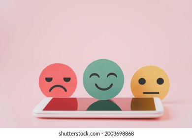 Green Good Emotion Face On Blurred White Mobile Phone In Soft Focus ,customer Review, Comment, Experience, Satisfaction Survey, Feed Back, Health Counselor ,center For Psychological Wellness Concept