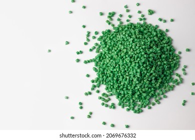 green granules of polypropylene or polyamide on a white background. Plastics and polymers industry. Copy space. Macro