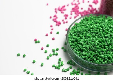 Green  granules of polypropylene or polyamide on a white background. Plastics and polymers industry. Copy space. Glass petri dish, flask, volumetric glassware, test tube.