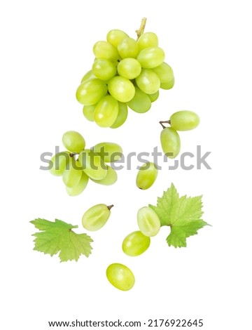 Green grape with leaves flying in the air isolated on white background.