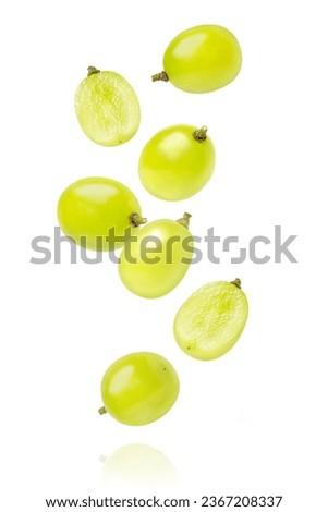 Green grapes with cut in half sliced flying in the air isolated on white background.