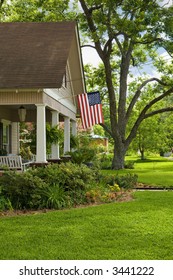 Green Grass, Blue Sky And Old House With American Flag