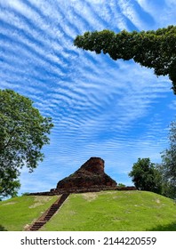 Green Grass And Brown Stone Steps Lead To The Brown Stone Structure On A High Hill. Against The Blue Sky With White Wavy Clouds Looks Beautiful.