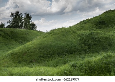 Green Grass Hill And Blue Sky With White Clouds.