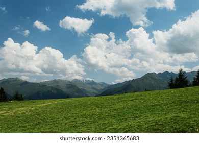 green grass on the background of mountains and clear sky with clouds - Powered by Shutterstock