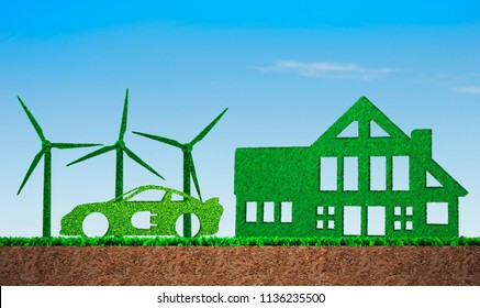 Green Grass In Shape Of Wind Turbines, Electric Car And Building, On Blue Sky And Meadow Soil Cross Section Background, Concept Of ECO, Renewable Energy And Circular Economy.