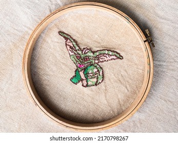 Green Gremlin In Wooden Hoop Embroidered By Hand On Fabric Close Up