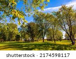 Green groomed lawns, trees with green, yellow, orange and yellow foliage. Canada. Bright fall colors. Province of Quebec. Gorgeous bright autumn landscape. 