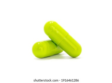 Green herbal medicine capsules isolated on white background