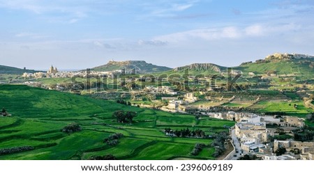 Green hills with church visible in distance - panoramic view from the Old medieval citadel (Citadella) in Victoria, capital city of Gozo island, Malta - January 2022