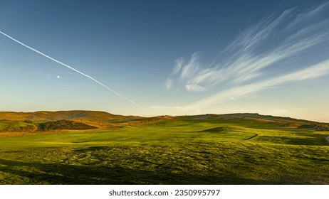 Green hills under blue sky at the golden hour. - Powered by Shutterstock