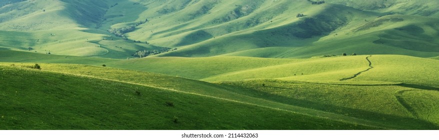 Green hillsides in the evening light, spring greenery, panoramic view