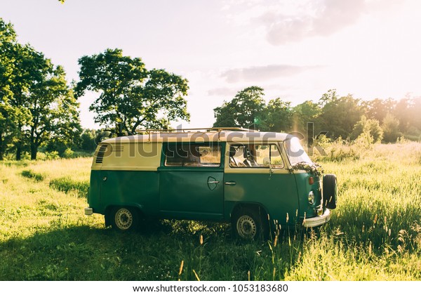 green\
hippie bus in green forest photographed at\
sunset