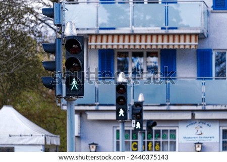 Green iight of pedestrian traffic light at zebra crossing at Swiss City of Zürich on a blue cloudy spring day. Photo taken March 21st, 2024, Zurich, Switzerland.