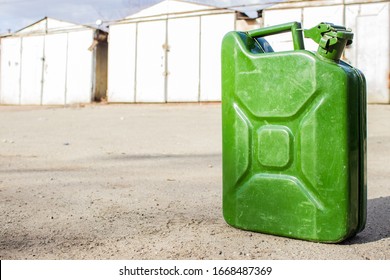 Green jerry can close-up on blurred background of garages. Copy space for your text