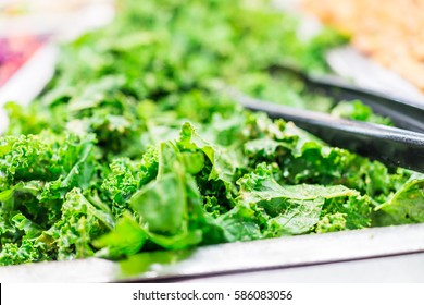 Green Kale Leaves In Salad Bar With Tongs