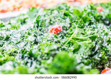 Green Kale Leaves And Tomatoes In Ceaser Salad Bar With Tongs