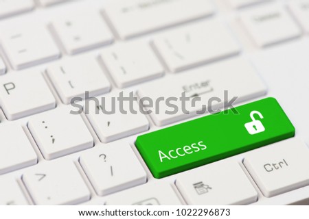 Green key with text Access and open padlock icon on white laptop keyboard.