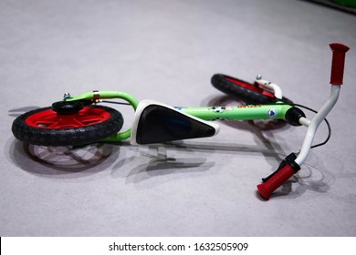 A Green Kids Bicycle Fallen On The Ground