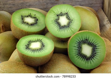 Green Kiwi Fruit And Some Cut Ones In A Wooden Box