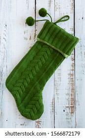 Green Knit Christmas Stocking On Wooden Background