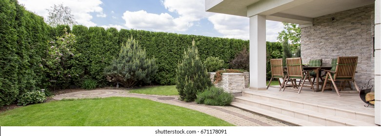 Green Lawn And Terrace With Garden Furniture