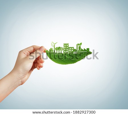 Green leaf in hand. ecology concept with the green city. climate change reducing by eco-friendly technology and development city- Environment day