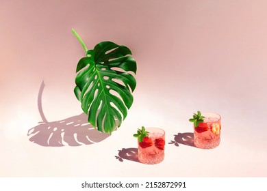 Green leaf of monstera and cocktail glasses on sunny day. Minimal concept on pastel pink background. - Powered by Shutterstock