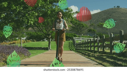 Green leaves and red heart icons against african american woman riding electric scooter in the park. green environment concept - Powered by Shutterstock