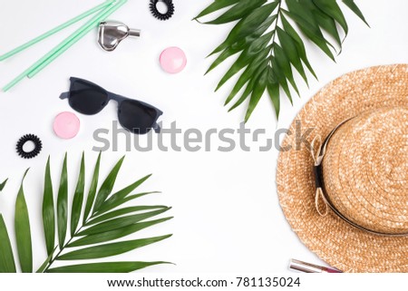 Green leaves and summer feminine acessories on the white background