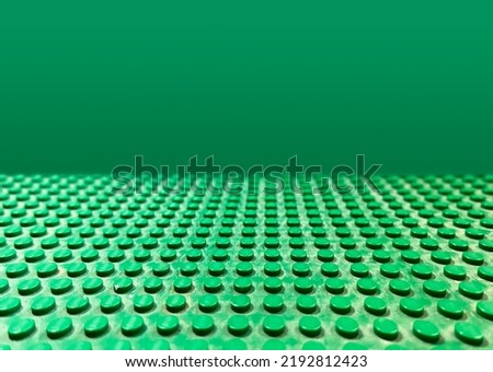 Green Lego ground surface with perspective on a green background