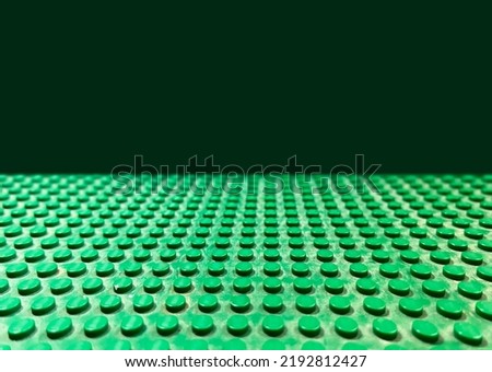 Green Lego ground surface with perspective on a dark background