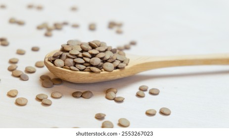 Green lentils in a wooden spoon, close-up. Cereals are useful for trace elements and vitamins. Variety in nutrition due to cereals. - Powered by Shutterstock