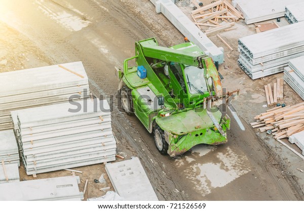 Green lift truck\
on construction site top\
view
