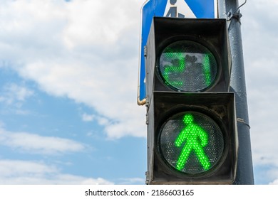 Green light on a pedestrian traffic light against a blue sky. Safe crossing of the road by pedestrians. Place for writing, copy space.