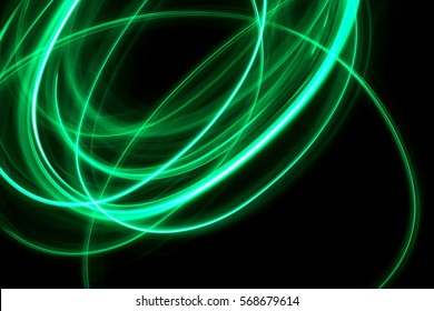 Green Light Painting Photography, loop and swirl against a black background