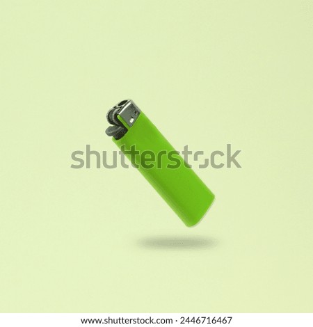 Green lighter levitating on green background with shadow